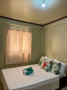a bedroom with a bed with a stuffed animal on it at Casa Huway in El Nido