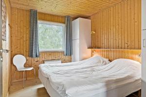 a bedroom with a bed and a chair in it at OH253-Hadsund-Halvrebene-37 in Hadsund