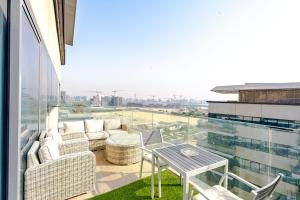 アブダビにあるSophisticated 2BR in Mayan with Golf View 905の建物の上にテーブルと椅子が置かれたバルコニー