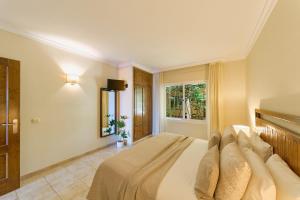 a bedroom with a bed and a window at SANTA CRUZ SUITE Jardín con vistas Mijas Costa in Málaga +21 photos