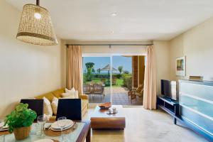 a living room with a couch and a tv at SANTA CRUZ SUITE Jardín con vistas Mijas Costa in Málaga