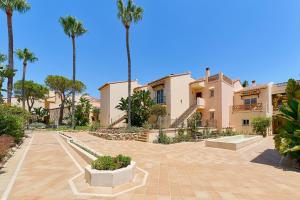 a large house with palm trees in front of it at SANTA CRUZ SUITE Jardín con vistas Mijas Costa in Málaga