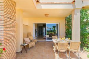 a patio with a table and chairs on a patio at SANTA CRUZ SUITE Jardín con vistas Mijas Costa in Málaga