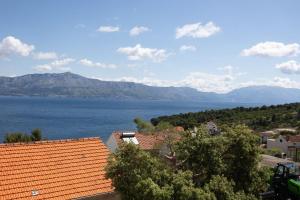a view of a large body of water with mountains at Apartments Soni in Postira
