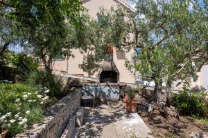 a house with trees and a stone walkway at Apartments Soni in Postira +45 photos