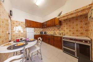 a kitchen with wooden cabinets and a table and chairs at Bairro Apartment in Lagos in Lagos