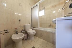 a bathroom with a toilet and a sink at Bairro Apartment in Lagos in Lagos +50 photos
