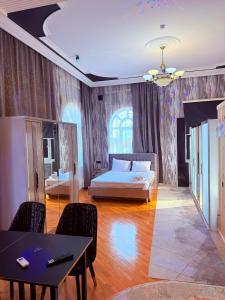 a bedroom with a bed and a table and chairs at Hotel Badamdar Baku in Baku