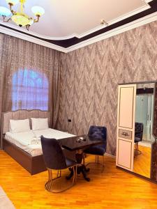 a bedroom with a bed and a table and chairs at Hotel Badamdar Baku in Baku