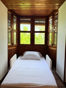 a bed in a room with two chairs and two windows at Casa Petra in Morillo de Monclús