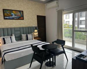 a bedroom with a bed and a table and chair at KDS Residency Hotel and Banquet in Greater Noida