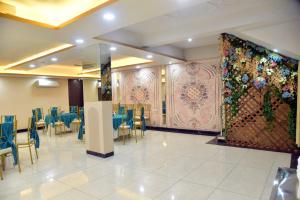 a restaurant with blue tables and chairs and a wall at KDS Residency Hotel and Banquet in Greater Noida