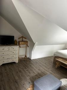 a bedroom with a bed and a dresser with a television at Maison Jazharra -SPA - 6 - 8 pers - Proche Golf in Frehel +93 photos