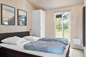 a bedroom with a bed with two pillows and a window at OH165-Hadsund-Bakkerne-2 in Hadsund