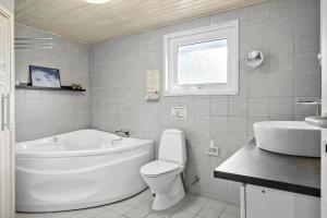 a bathroom with a tub and a toilet and a sink at OH165-Hadsund-Bakkerne-2 in Hadsund +14 photos