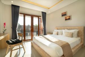 a bedroom with a large bed and a balcony at Narmada House Seminyak in Seminyak