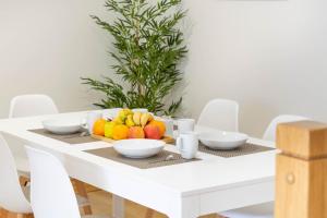 einen weißen Tisch mit einer Schale Obst drauf. in der Unterkunft Amplia casa rural con barbacoa y jardín en Navarra in Olcoz