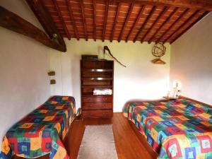 a bedroom with two twin beds and a dresser at Cottage in Pescia with Pool & Garden in San Quirico