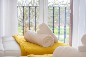 a towel sitting on a couch next to a window at Amplia casa rural con barbacoa y jardín en Navarra in Olcoz