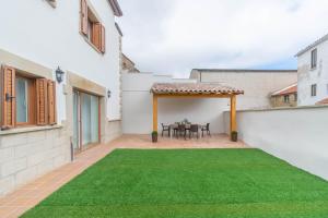 a patio with a table and a green lawn at Amplia casa rural con barbacoa y jardín en Navarra in Olcoz