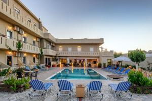 um hotel com piscina e cadeiras e um edifício em Despina Apts by Estia em Gouves