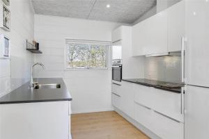 a white kitchen with a sink and a refrigerator at OH306-Hadsund-Ridestien-3 in Hadsund
