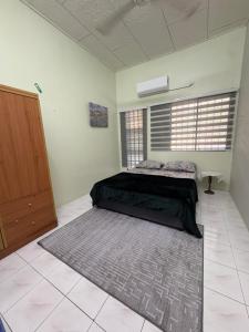 a bedroom with a bed and a large rug at Nadis Guesthouse in Ipoh