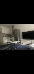 a living room with a table and a tv at Joy Vulcan Center apartment in Oslo +6 photos