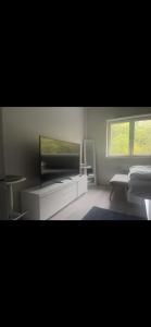 a living room with a flat screen tv on a cabinet at Joy Vulcan Center apartment in Oslo