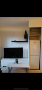 a living room with a white desk with a tv at Joy Vulcan Center apartment in Oslo