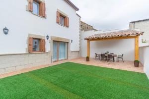 a patio with a table and a green lawn at Amplia casa rural con barbacoa y jardín en Navarra in Olcoz