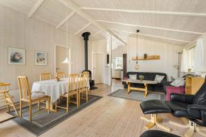 ein Esszimmer und ein Wohnzimmer mit Tisch und Stühlen in der Unterkunft 1419 Aakirkeby - Boesparken 16 in Vester Sømarken