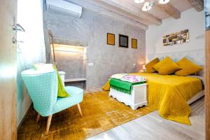 ein Schlafzimmer mit einem gelben Bett und einem blauen Stuhl in der Unterkunft Casa Smeralda in Rovinj