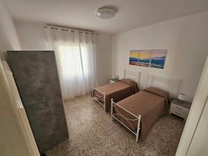 Un dormitorio con dos camas y una ventana. en The White House, en Torre Suda