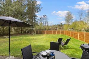einen Tisch und Stühle mit Sonnenschirm im Hof in der Unterkunft 1419 Aakirkeby - Boesparken 16 in Vester Sømarken + 14 Fotos