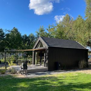 a shed with a table and chairs in a yard at Bay Zatoka Radzyń in Radzyń