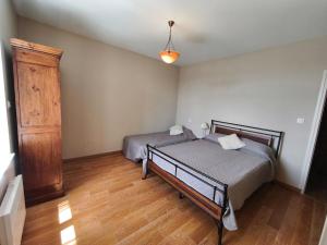 a bedroom with two beds and a wooden floor at Le Gîte de JC in Homps