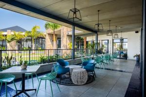 a restaurant with tables and chairs on a balcony at Ballito Hills 1153 in Ballito