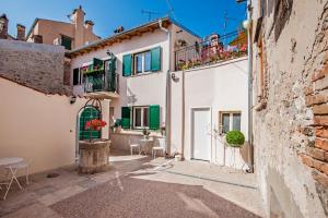 einen Innenhof mit weißen Gebäuden und grünen Rollläden in der Unterkunft Casa Smeralda in Rovinj