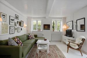 a living room with a green couch and a tv at 5522-Svaneke-Bakken-5 in Svaneke
