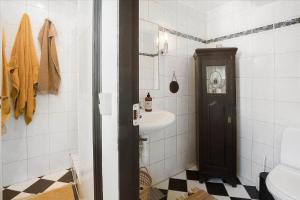 a white bathroom with a sink and a toilet at 5522-Svaneke-Bakken-5 in Svaneke +14 photos