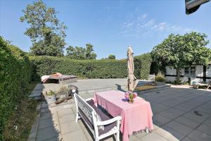 a patio with a pink table and an umbrella at 5522-Svaneke-Bakken-5 in Svaneke