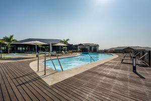a swimming pool with tables and umbrellas on a deck at Ballito Hills 1153 in Ballito