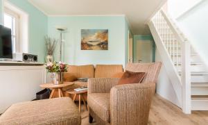 a living room with two chairs and a couch at Wellenzauber in Ahrenshoop