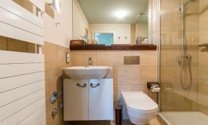 a bathroom with a sink and a toilet and a shower at Wellenzauber in Ahrenshoop +10 photos