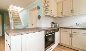 a kitchen with white cabinets and a bowl on the counter at Wellenzauber in Ahrenshoop