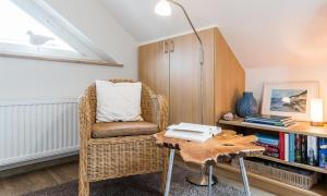 a living room with a wicker chair and a table at Wellenzauber in Ahrenshoop