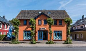 an orange building with trees in front of it at Wellenzauber in Ahrenshoop