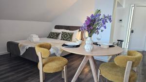 a bedroom with a table and a bed with purple flowers at A Proa do Moliceiro Canal da Ria Lagoon Views in Aveiro