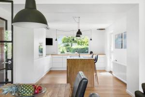 a kitchen with white walls and a table with a bowl of fruit at 6763-Allinge-Sdr-Strandvej-69 in Allinge